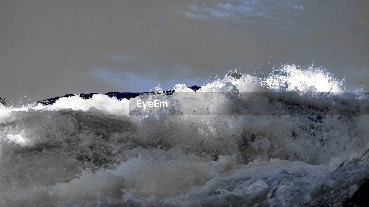 SCENIC VIEW OF SEA WAVES SPLASHING ON ROCKS