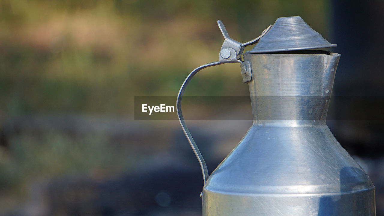 focus on foreground, food and drink, drink, close-up, no people, pitcher - jug, container, metal, refreshment, jug, nature, silver, water, drinkware, household equipment, outdoors