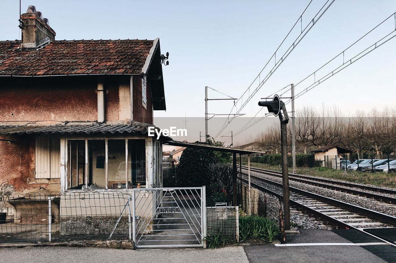 RAILROAD TRACKS BY BUILDINGS AGAINST SKY