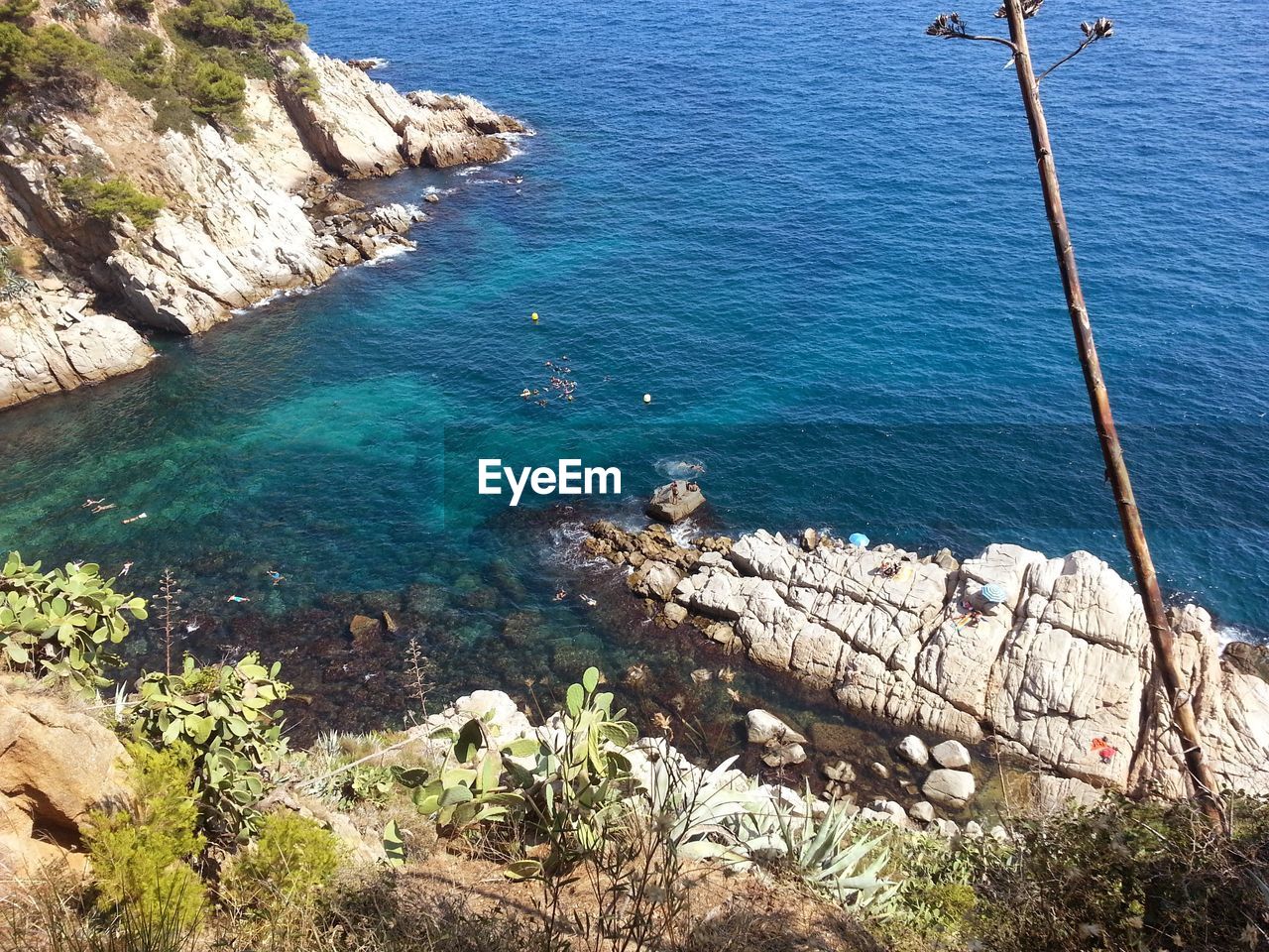 HIGH ANGLE VIEW OF ROCKS ON SEA