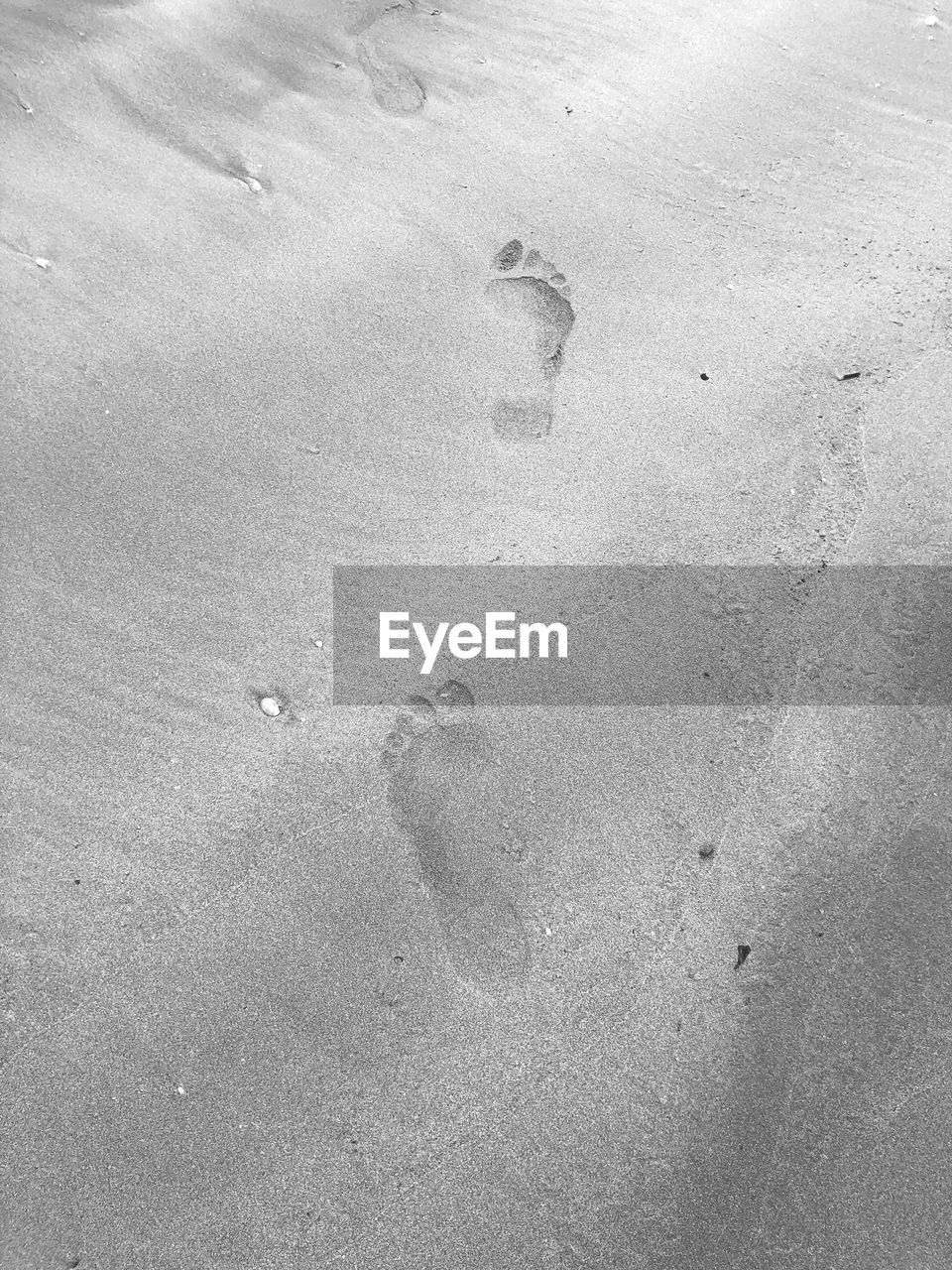 HIGH ANGLE VIEW OF FOOTPRINTS ON BEACH