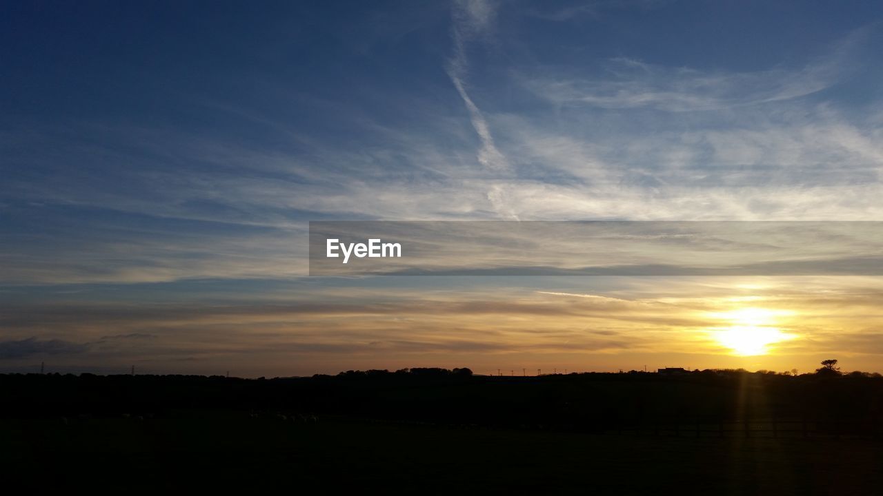 SCENIC VIEW OF SILHOUETTE FIELD AGAINST SKY AT SUNSET