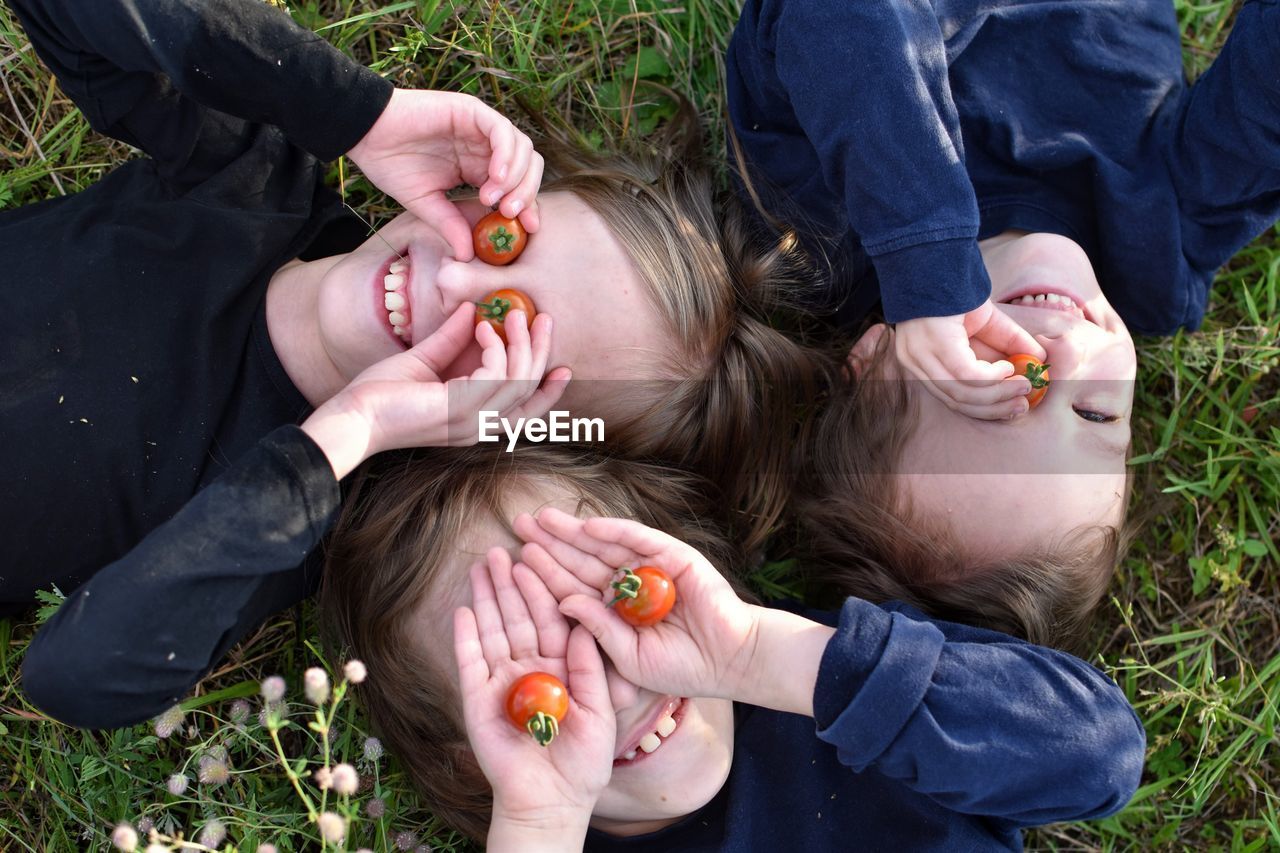 Close-up of children lying on grass