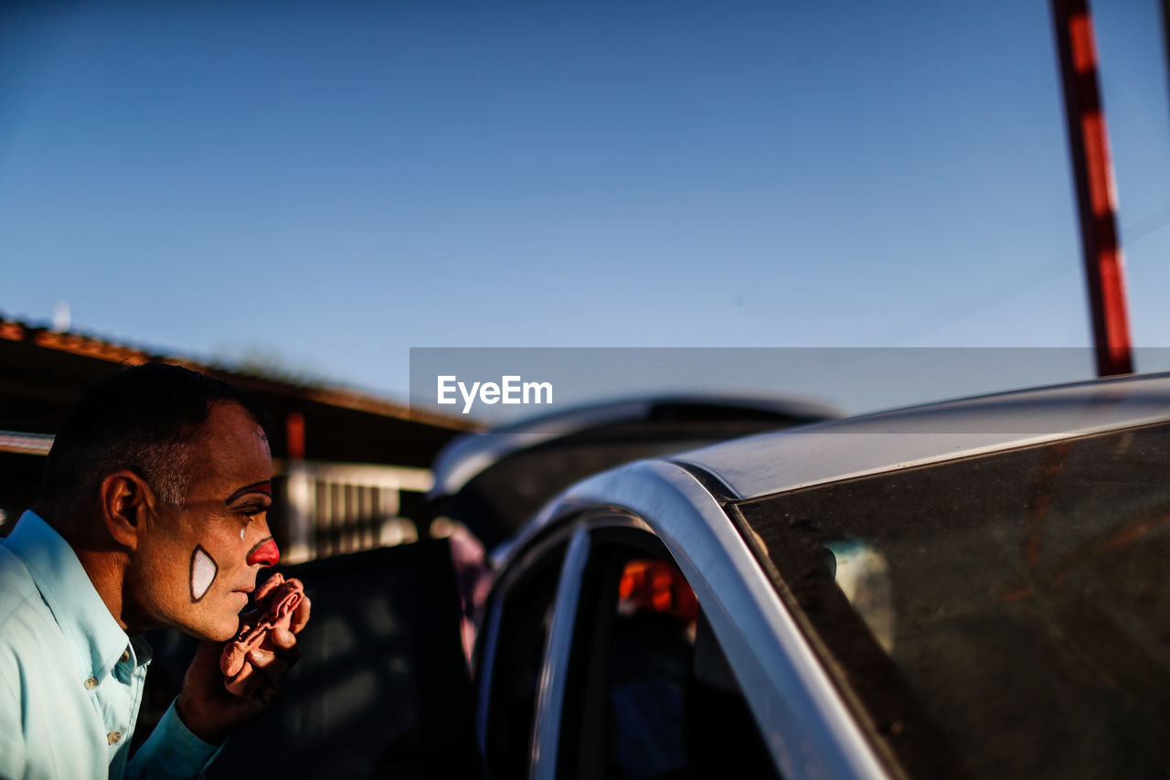 MAN USING MOBILE PHONE AGAINST SKY