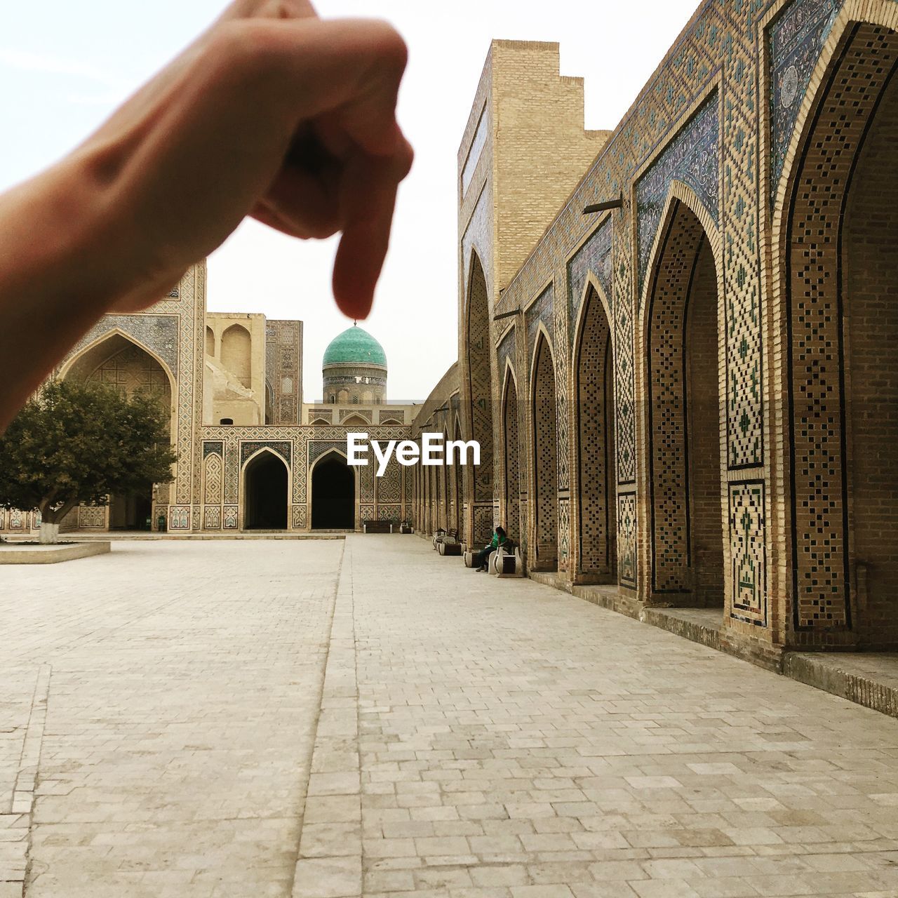 CROPPED IMAGE OF PERSON OUTSIDE TEMPLE BUILDING