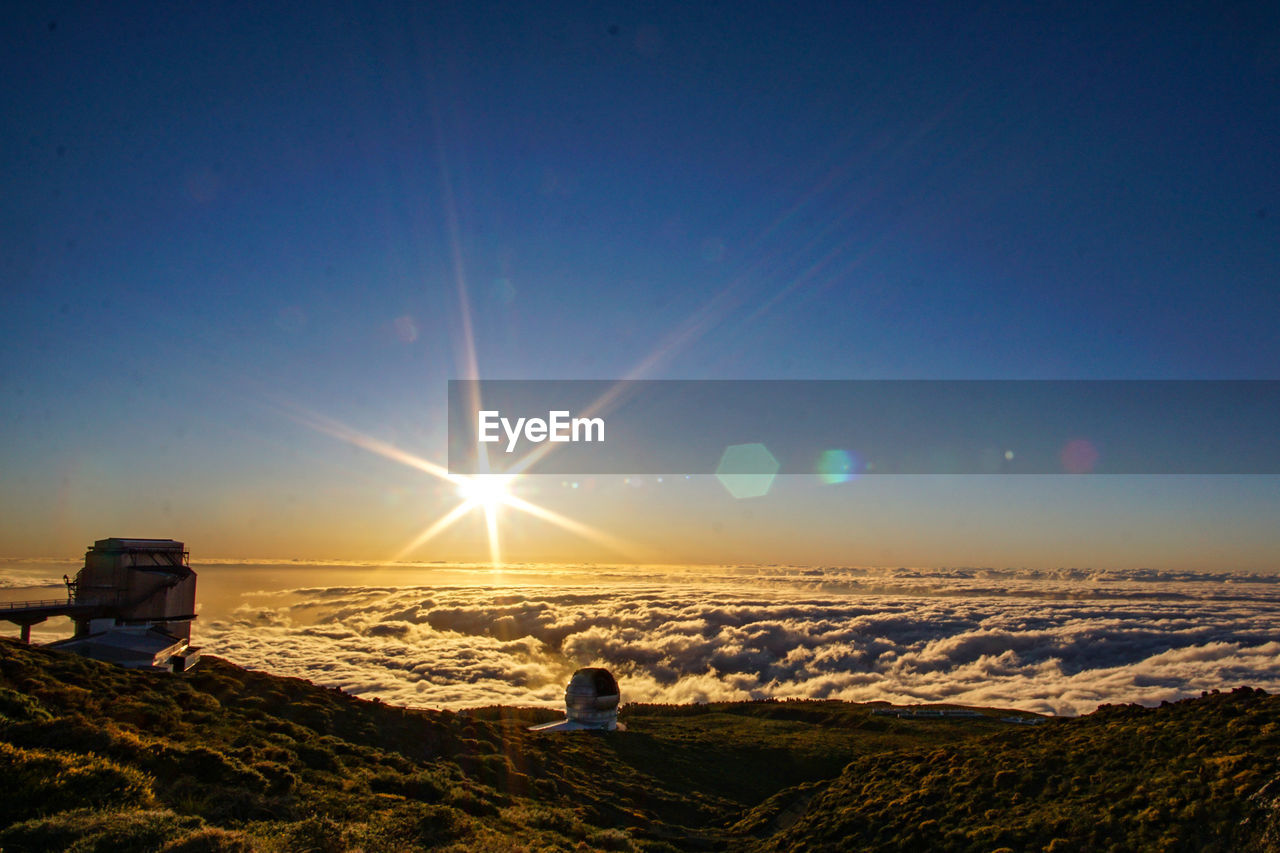 Rear view of man on land against sky during sunset