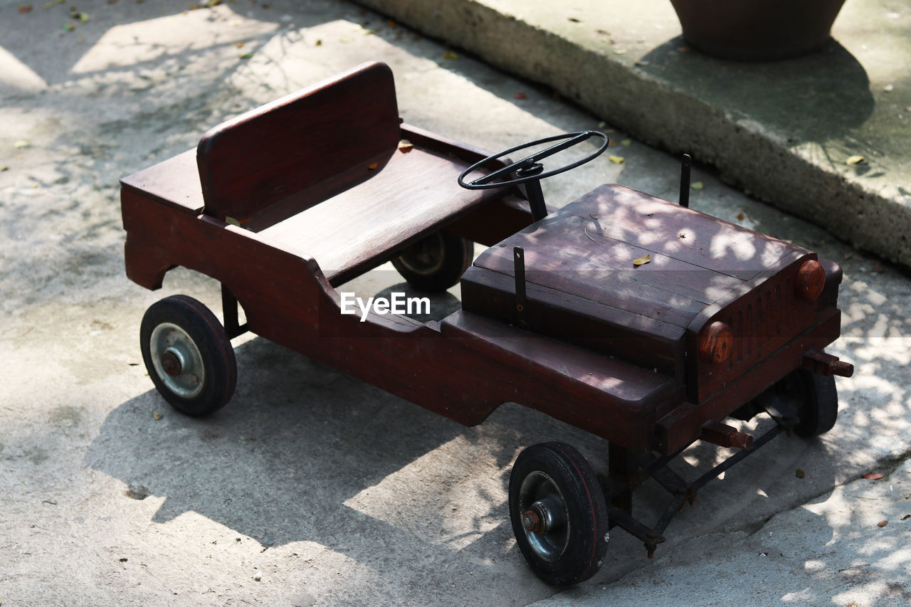 HIGH ANGLE VIEW OF TOY CAR ON WOOD