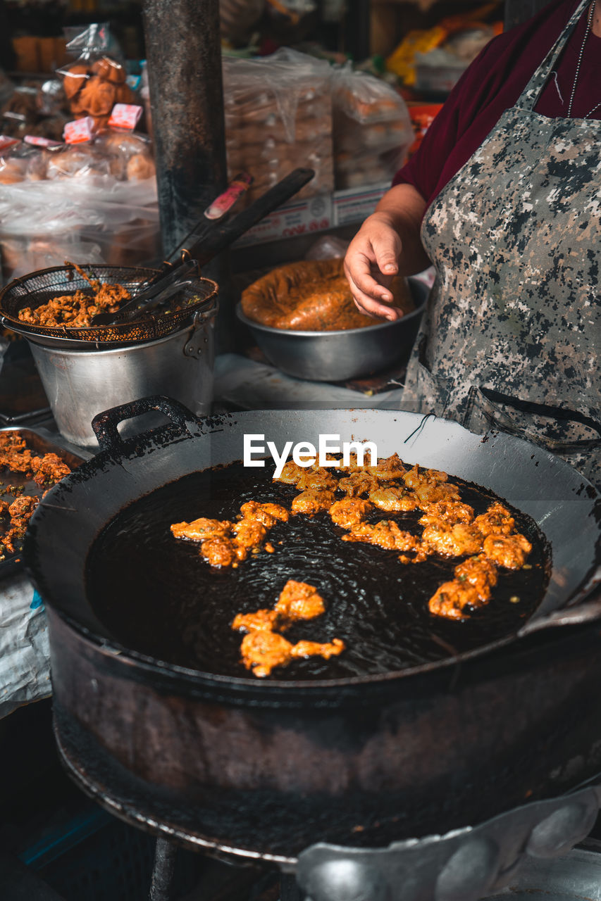 Midsection of person preparing food on barbecue grill