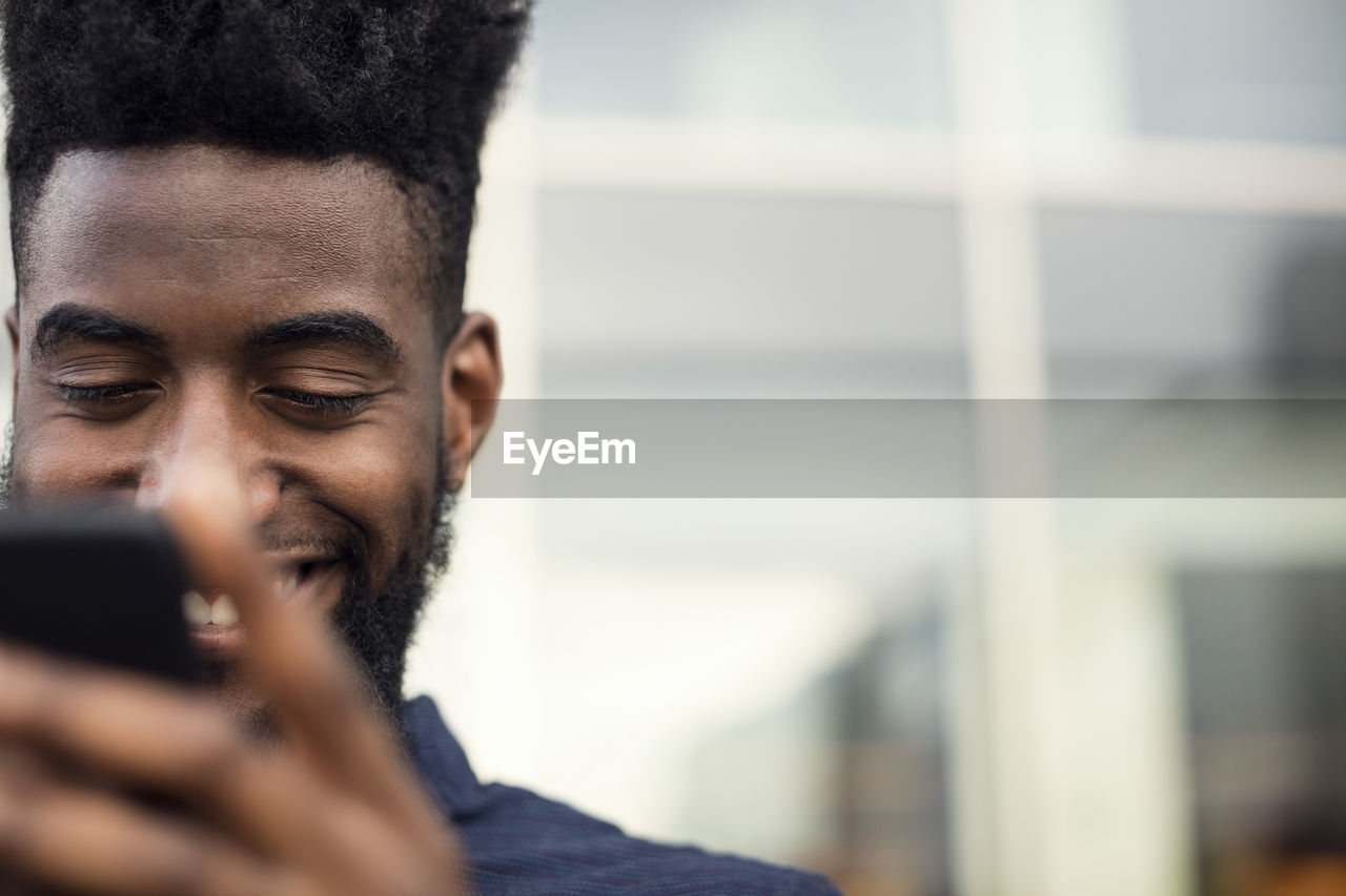 Low angle view of happy man using phone