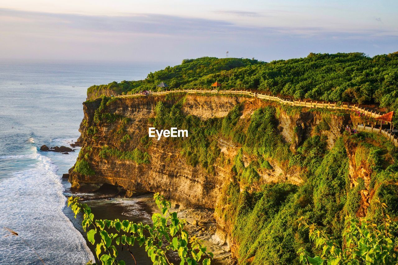 Cliff by sea against sky