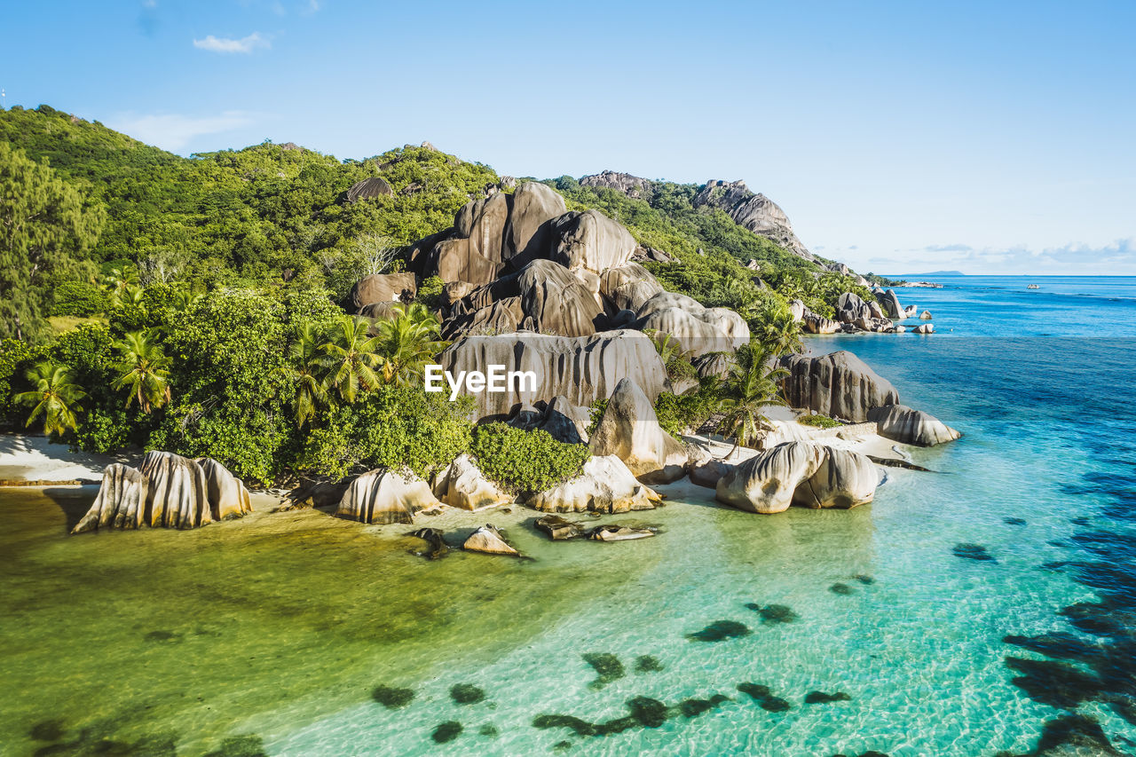 Aerial photo of seychelles tropical beach anse source d'argent in evening light at la digue island