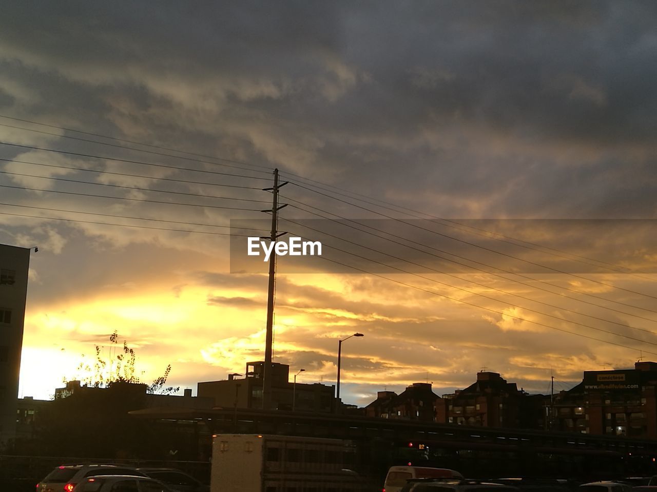 SILHOUETTE BUILDINGS IN CITY AGAINST ORANGE SKY