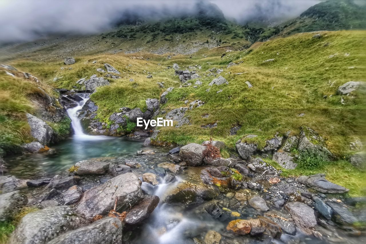 Scenic view of stream flowing through rocks