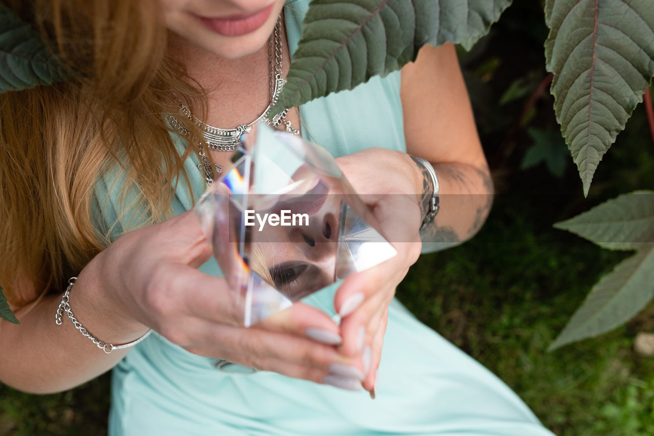 Midsection of woman holding crystal pyramid