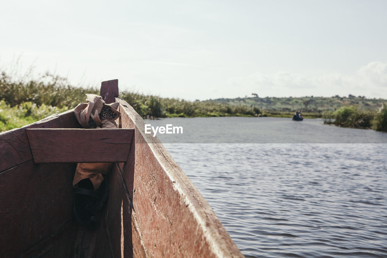 HIGH ANGLE VIEW OF MAN ON BOAT AGAINST SKY