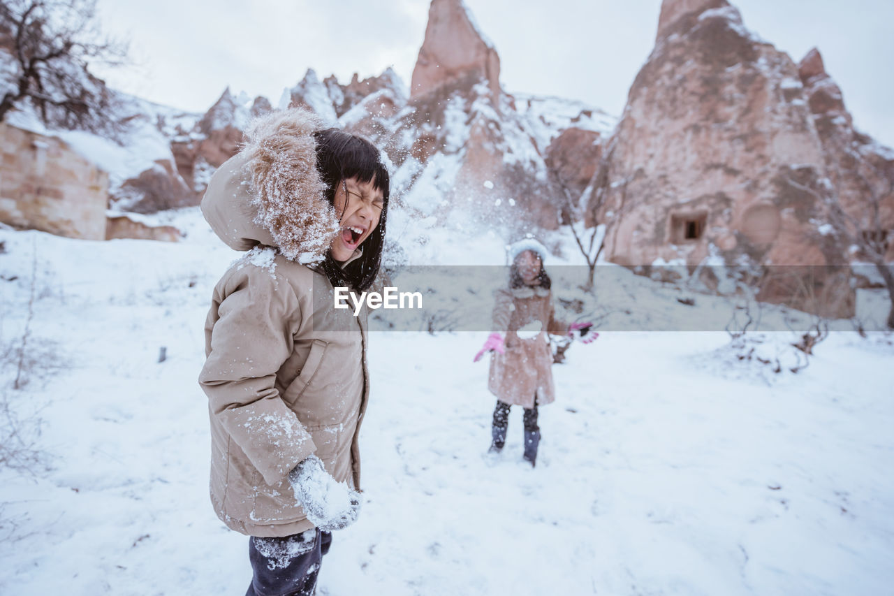 side view of young woman standing on snow