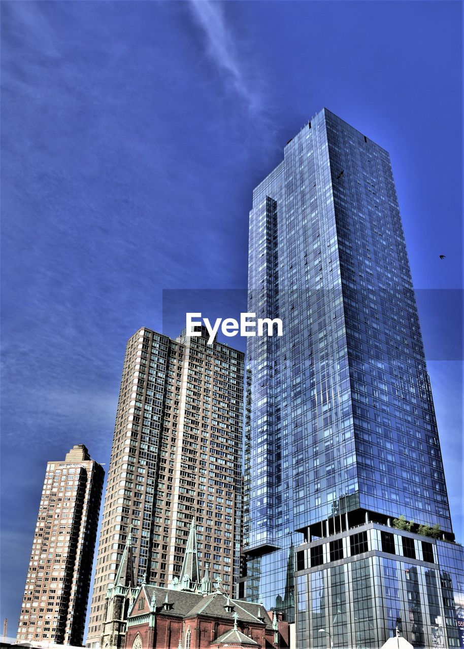 Low angle view of modern buildings against blue sky