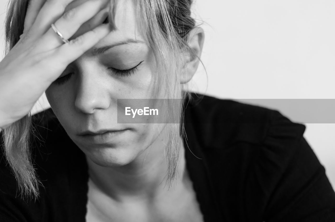 Close-up of sad woman against wall