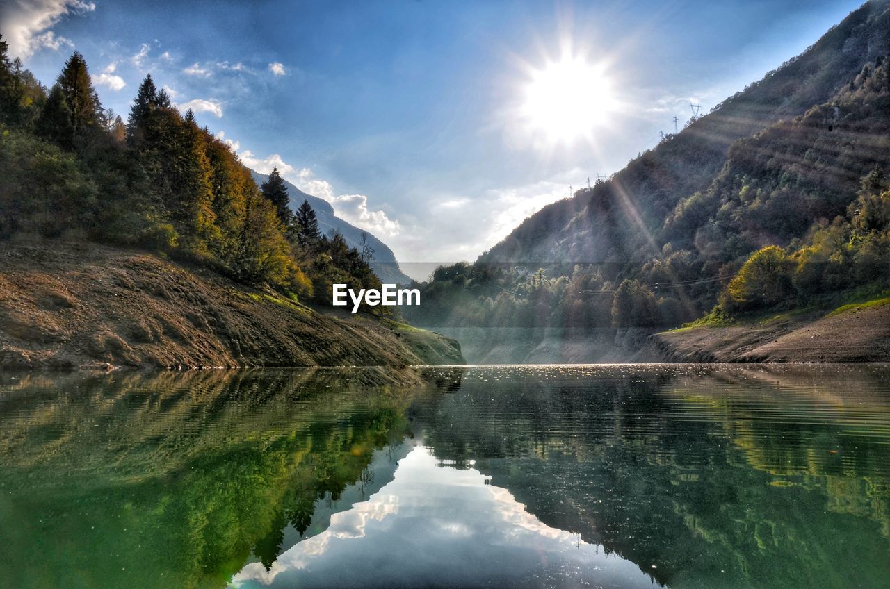 Scenic view of lake by mountains against sky