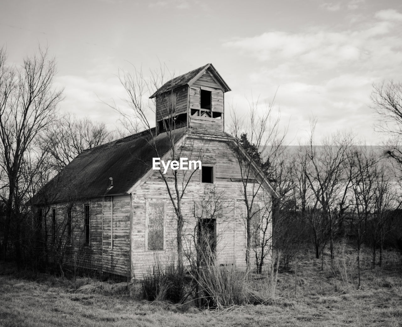 Abandoned house on field against sky