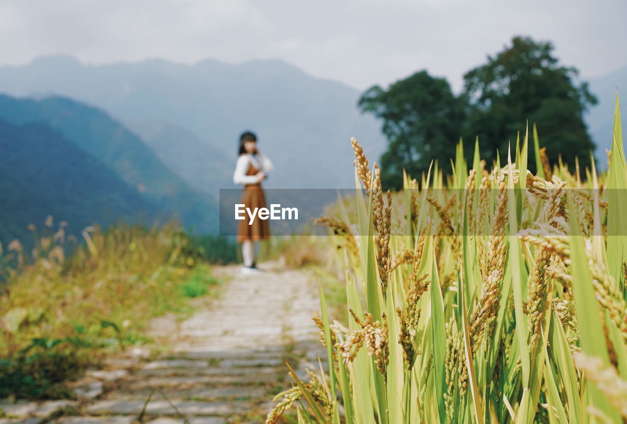 Woman standing on field against sky