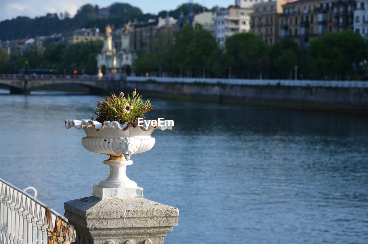 STATUE BY RIVER IN CITY