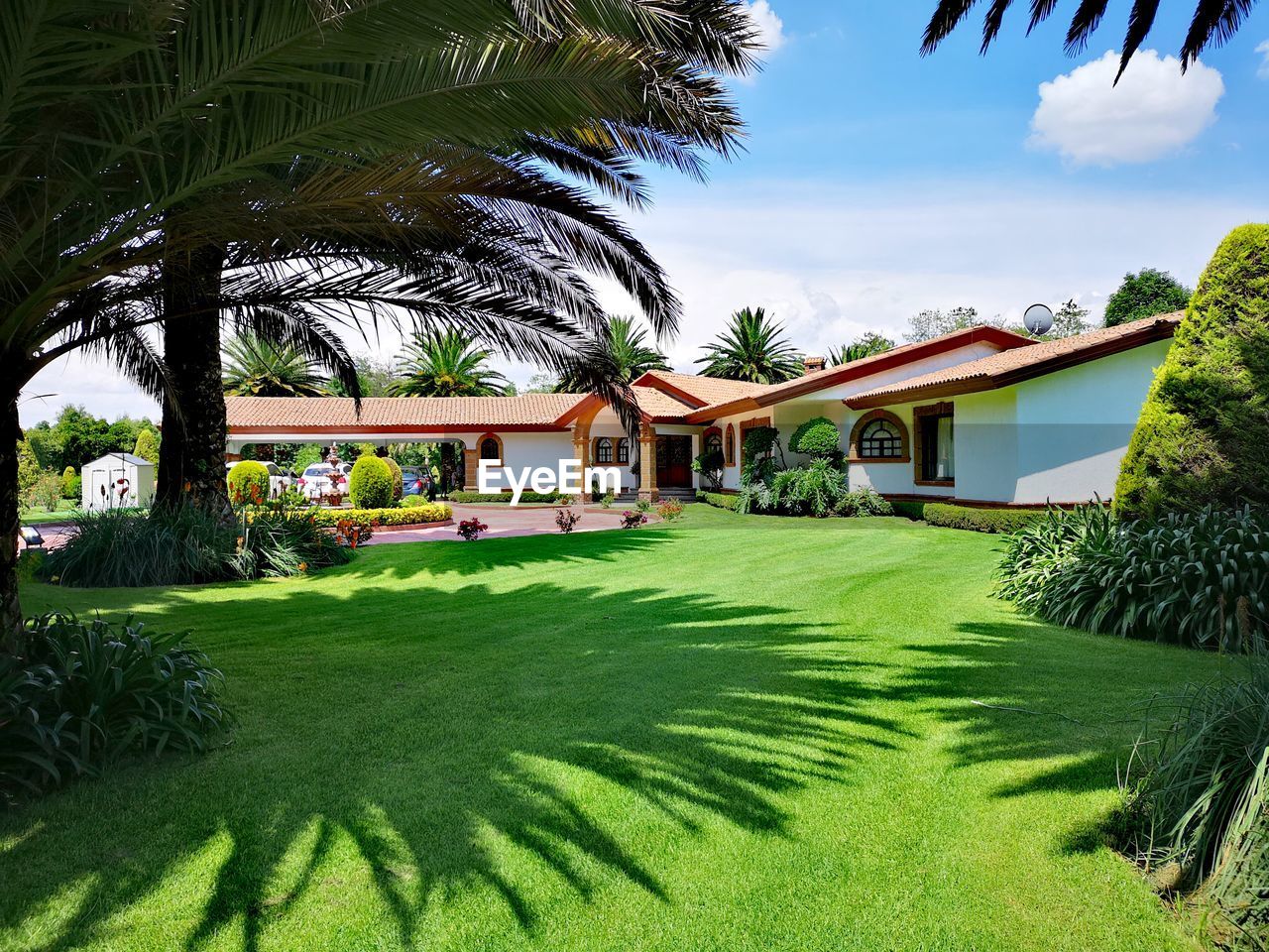 House by grassy field against sky