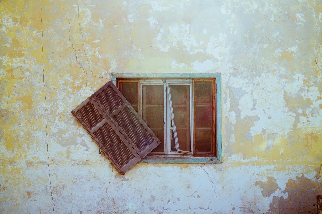 Window of abandoned house on wall