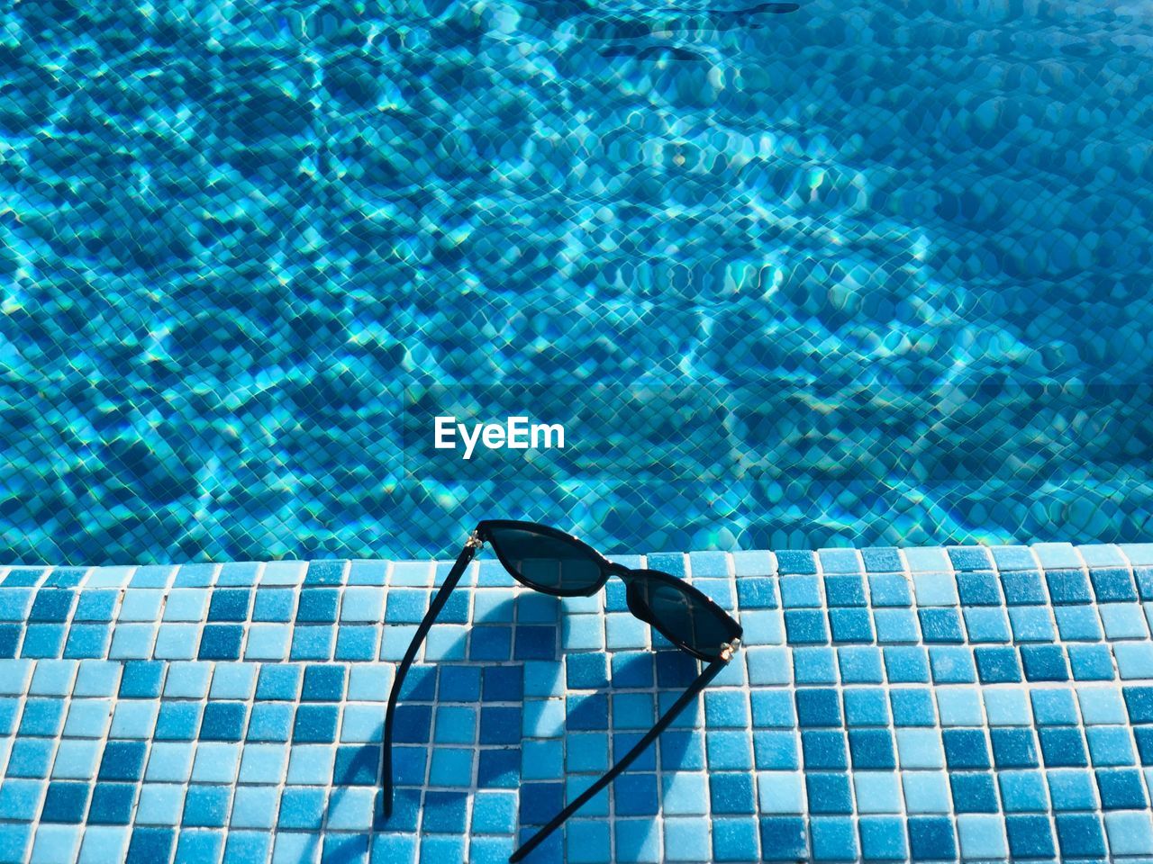 High angle view of sunglasses at poolside