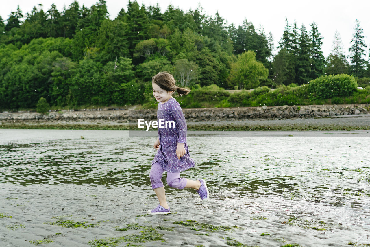 Closeup view of a young child running across a sandy beach