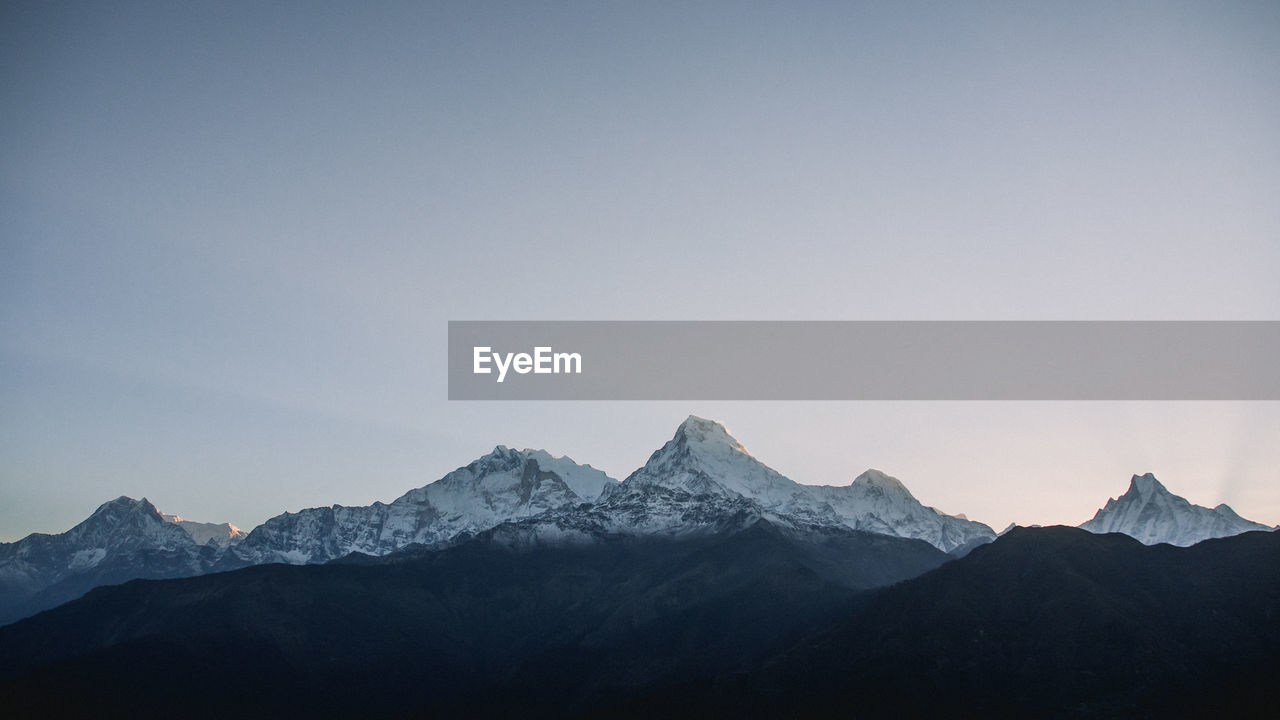 Scenic view of snowcapped mountains against clear sky