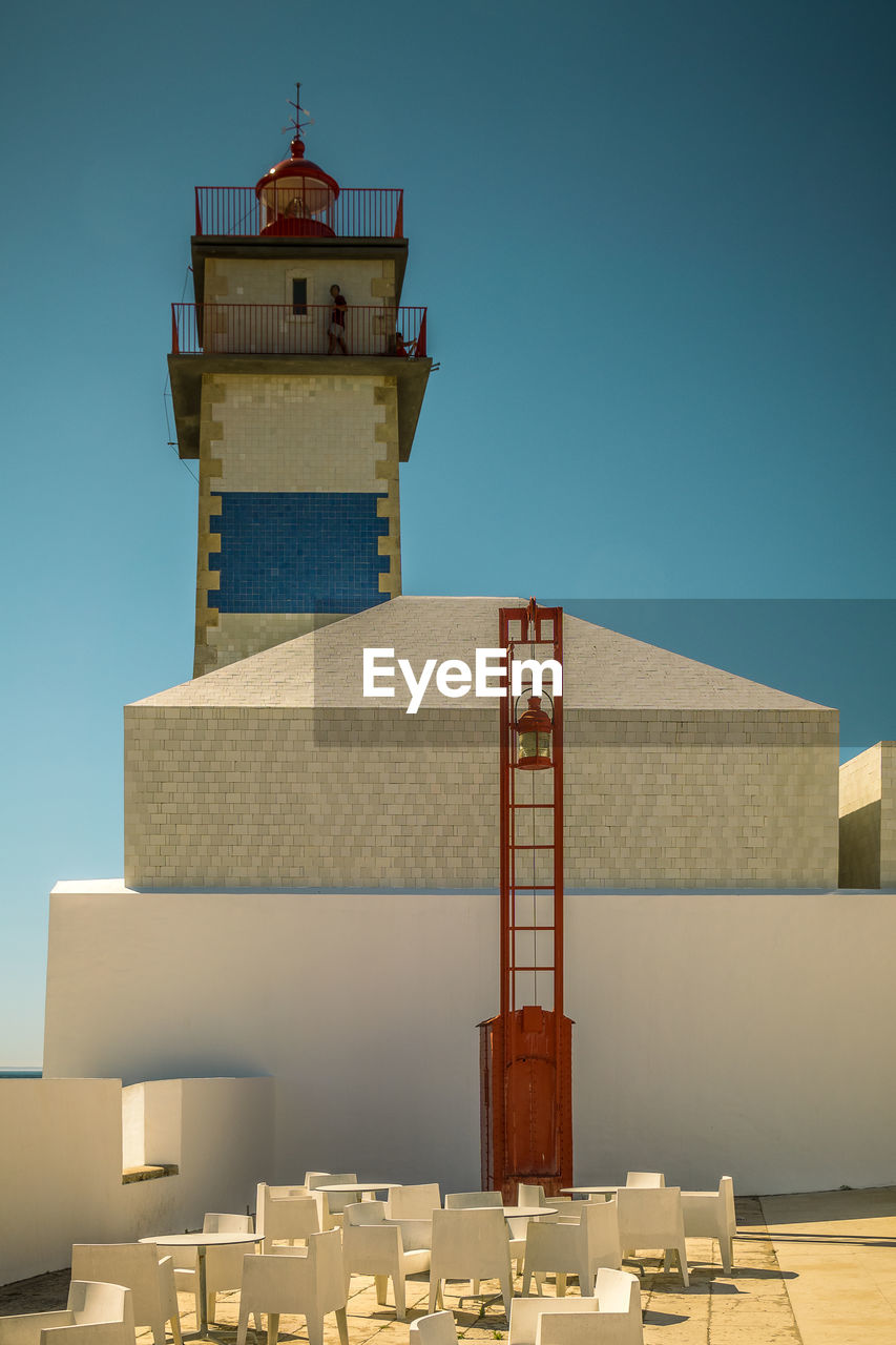 Low angle view of lighthouse tower against clear blue sky