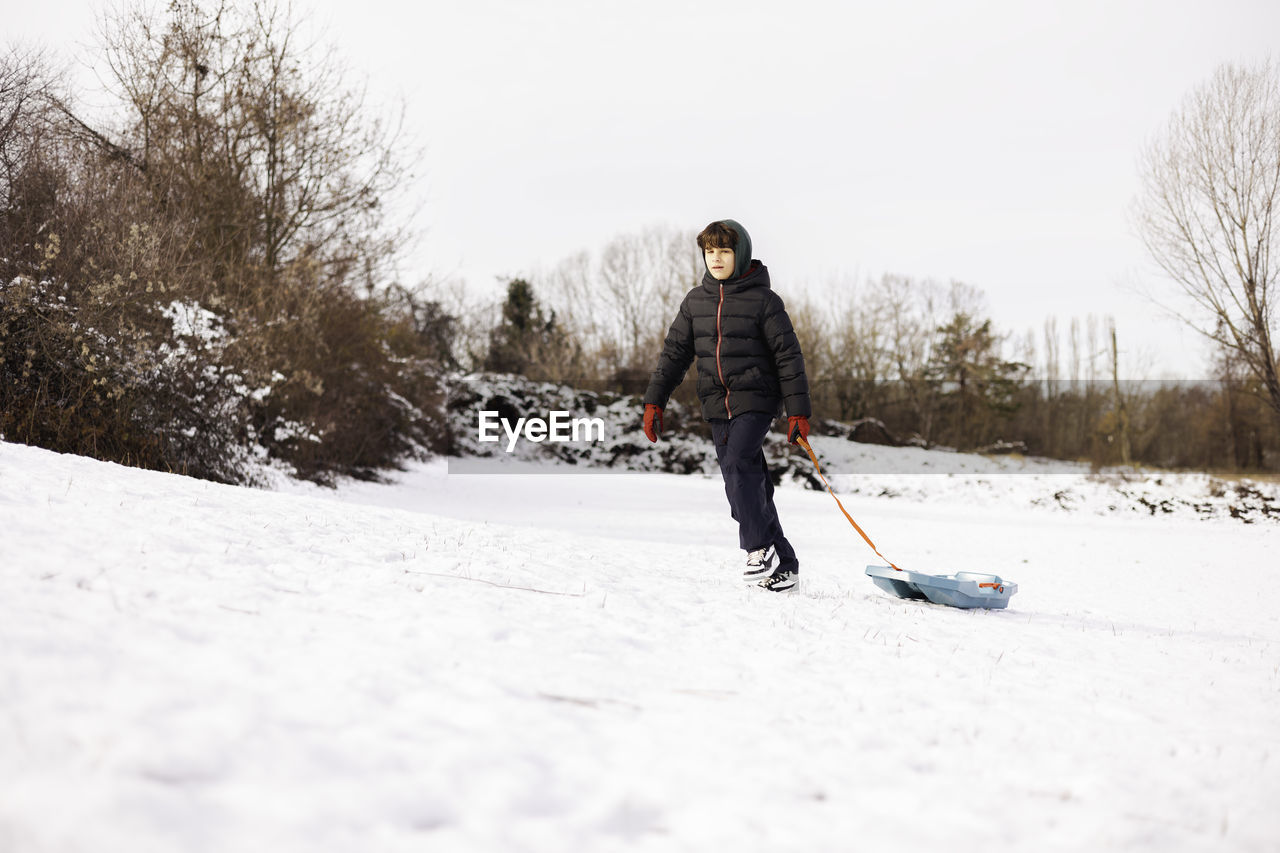 rear view of man skiing on snow covered field