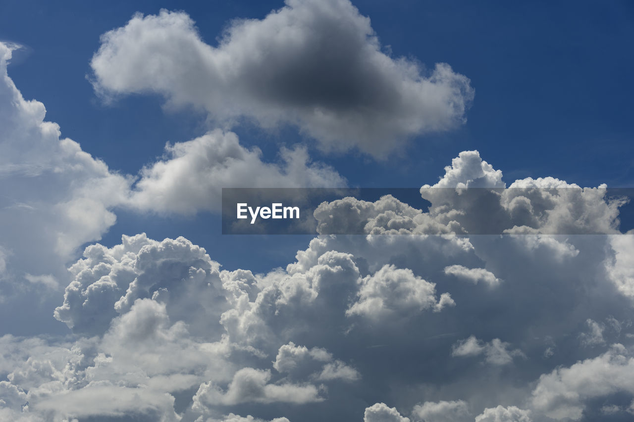 sky, cloud, daytime, blue, cloudscape, nature, environment, backgrounds, beauty in nature, atmosphere, fluffy, idyllic, wind, no people, white, overcast, outdoors, sunlight, dramatic sky, scenics - nature, high up, storm cloud, summer, religion, day, tranquility, airplane, flying, spirituality, animal wing, light - natural phenomenon, cumulonimbus, softness, travel, bright, sunny, fly, landscape, abstract
