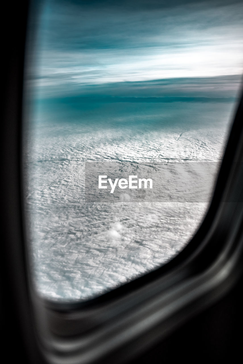 VIEW OF SEA THROUGH AIRPLANE WINDOW