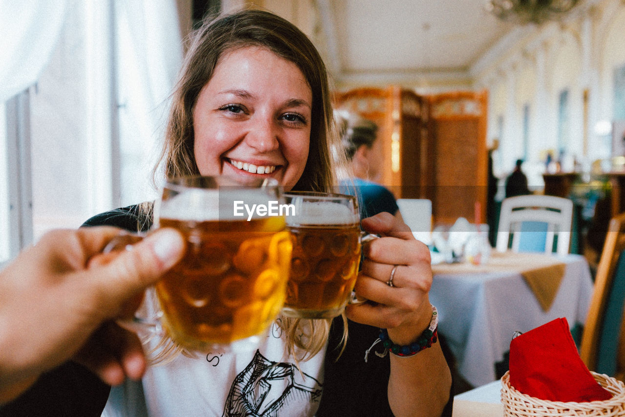 People toasting drinks in glass at restaurant