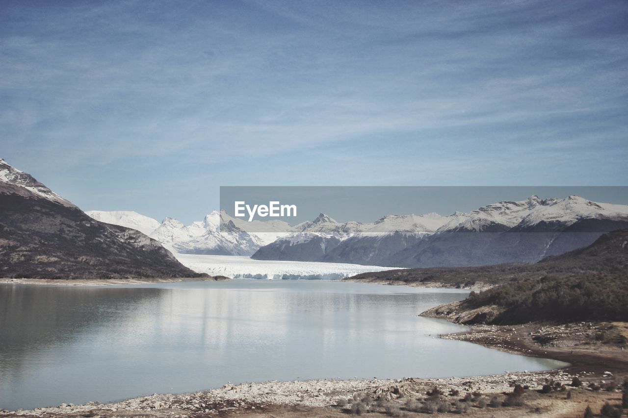 Scenic view of lake and snowcapped mountains against sky