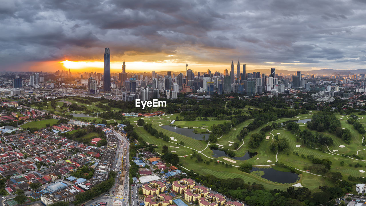 HIGH ANGLE VIEW OF BUILDINGS IN CITY AT SUNSET