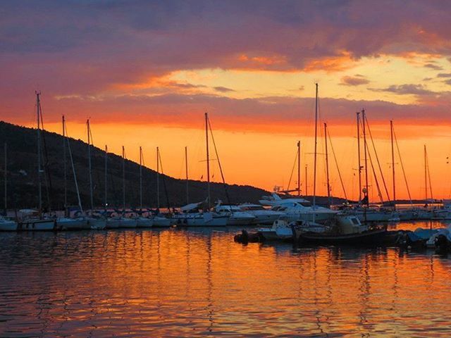 SAILBOATS IN SEA AT SUNSET