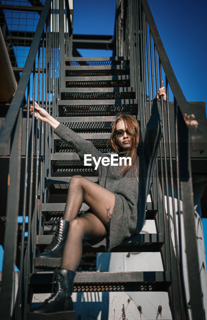 Portrait of smiling woman sitting on staircase