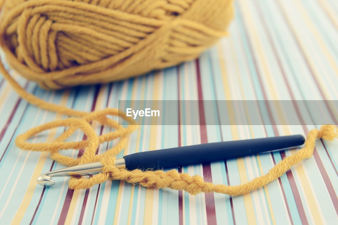 Close-up of knitting needle and wool on table