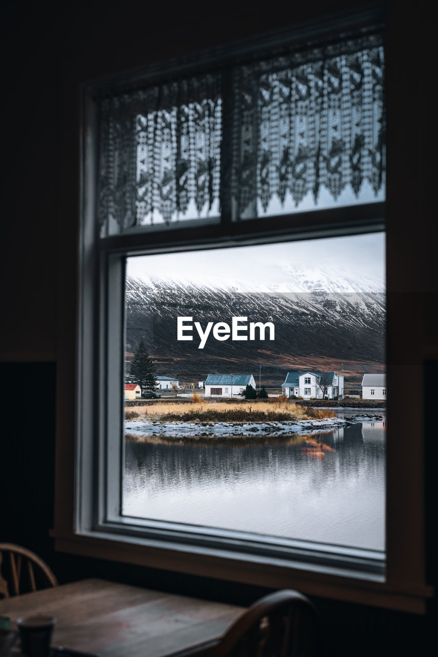 Reflection of building in glass window with scenic mountain background