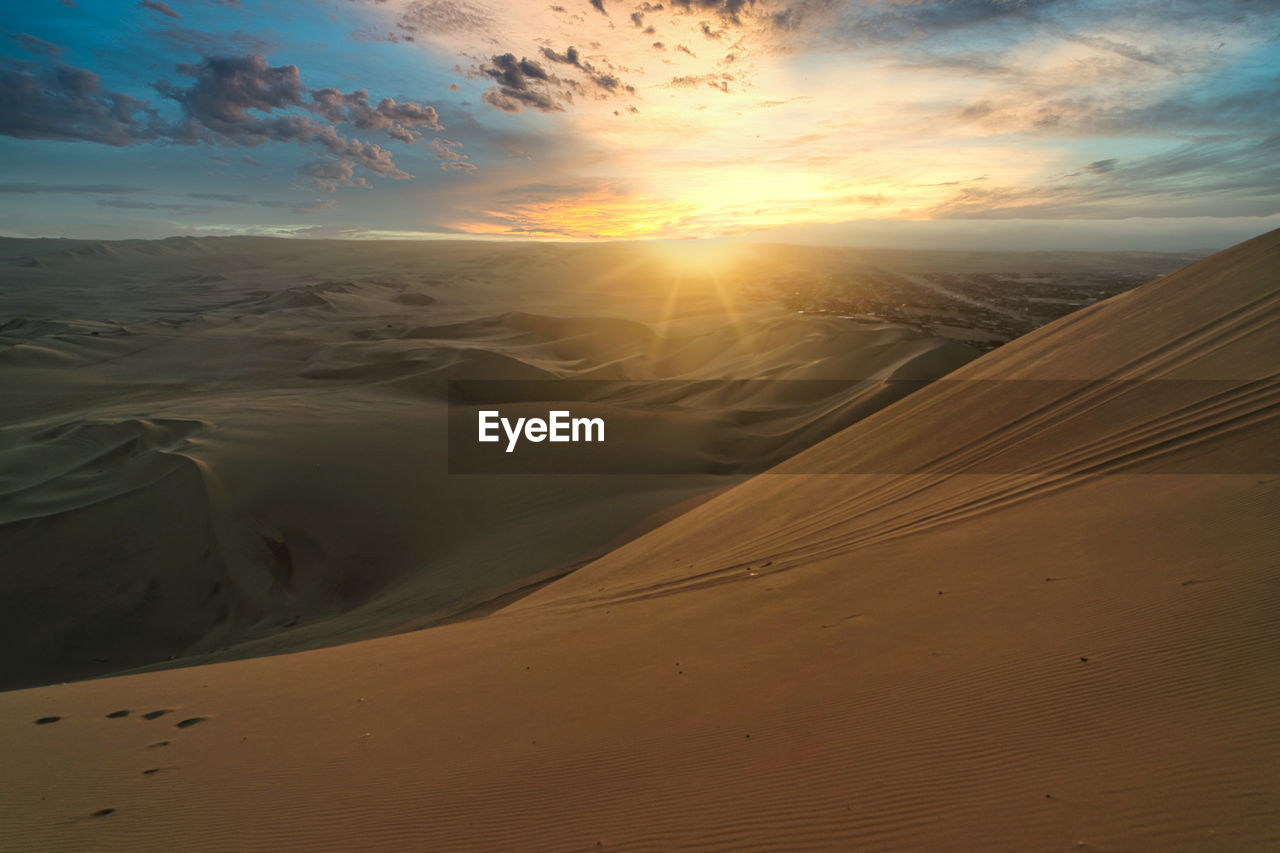 Scenic view of desert against sky during sunset