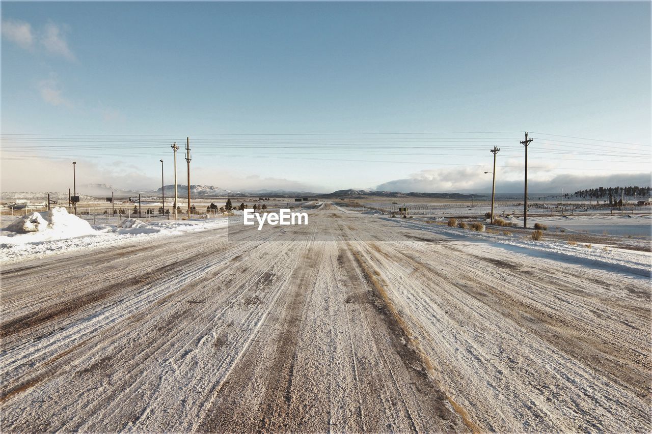 Snowy road against sky during winter