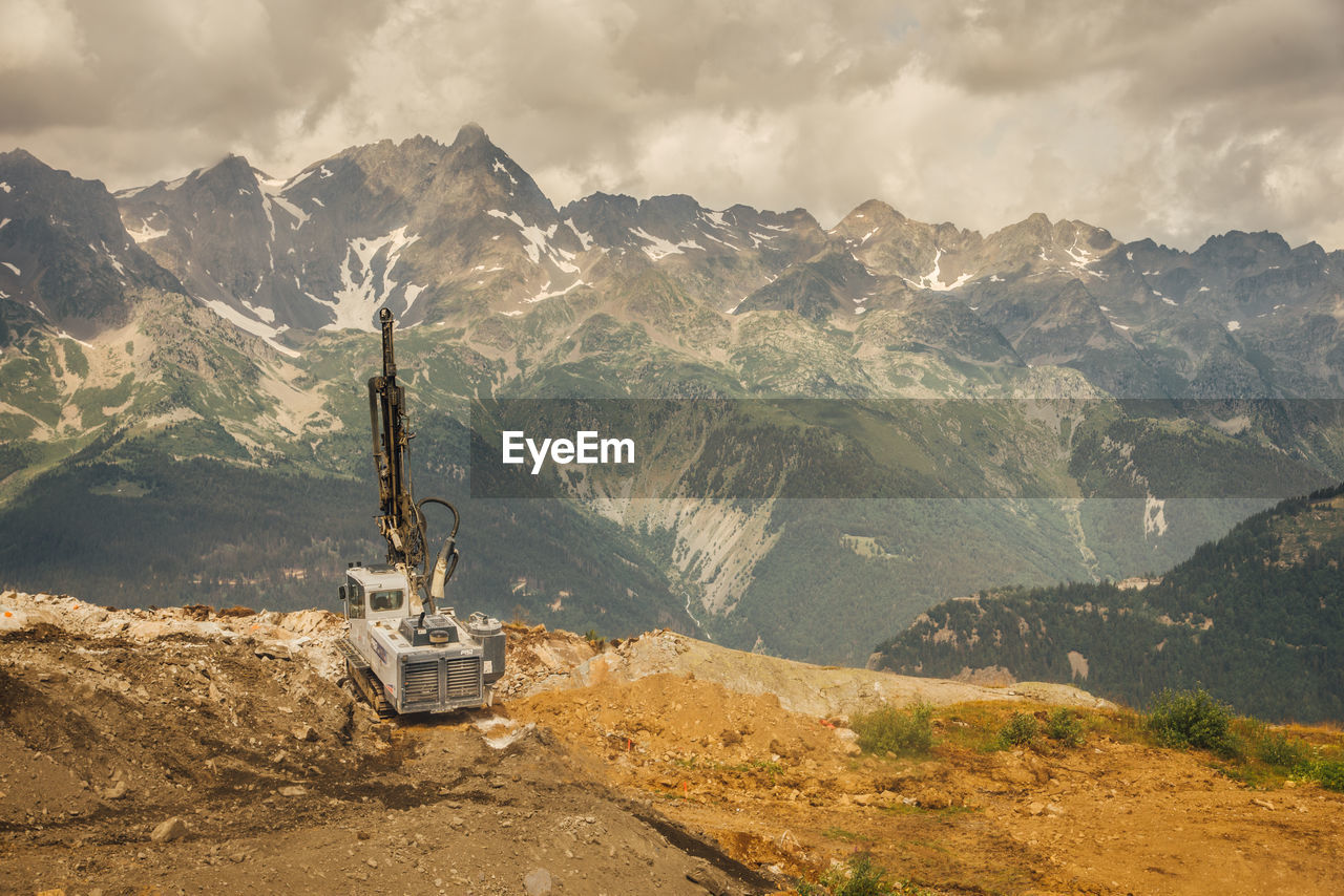 High angle view of construction machinery by mountains against sky