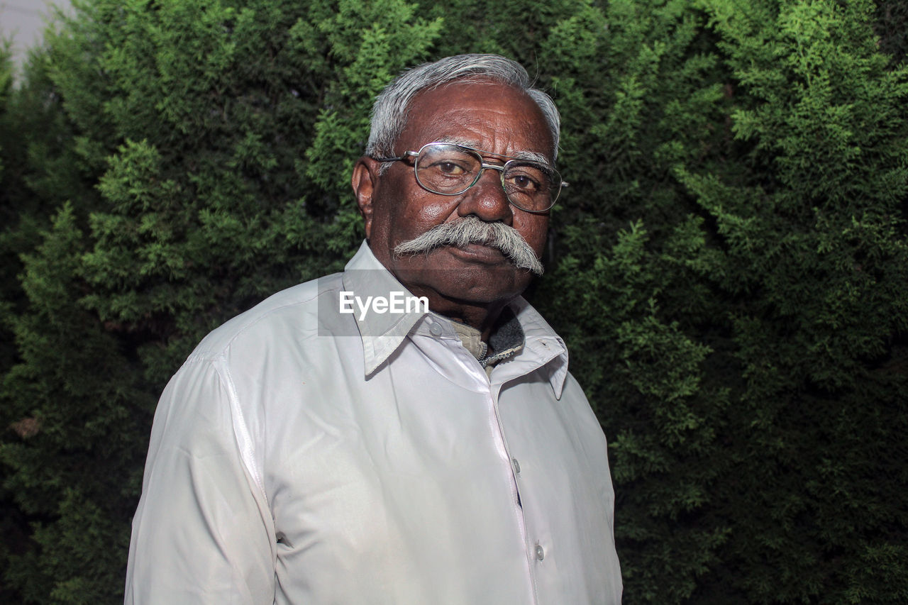 Portrait of senior man against plants