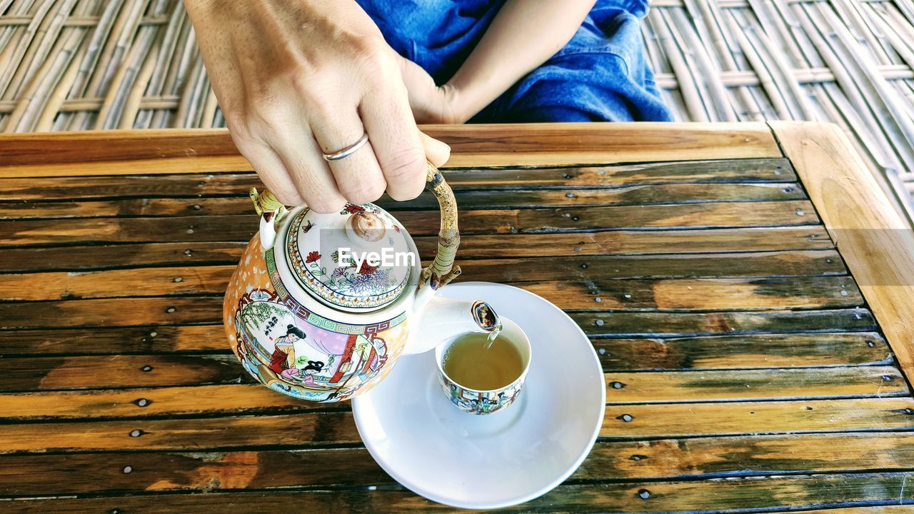 Midsection of woman pouring tea