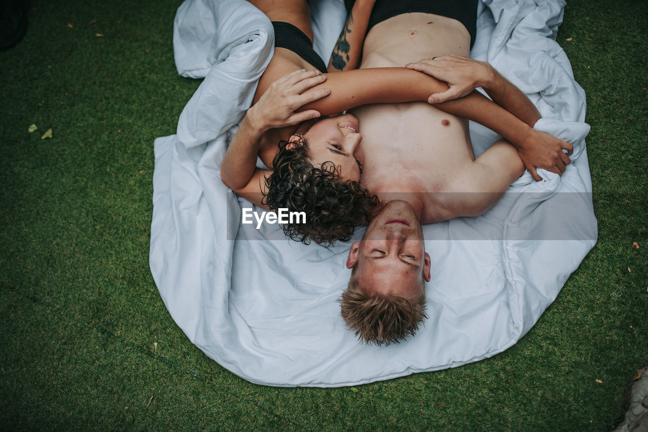 High angle view of couple lying on grass