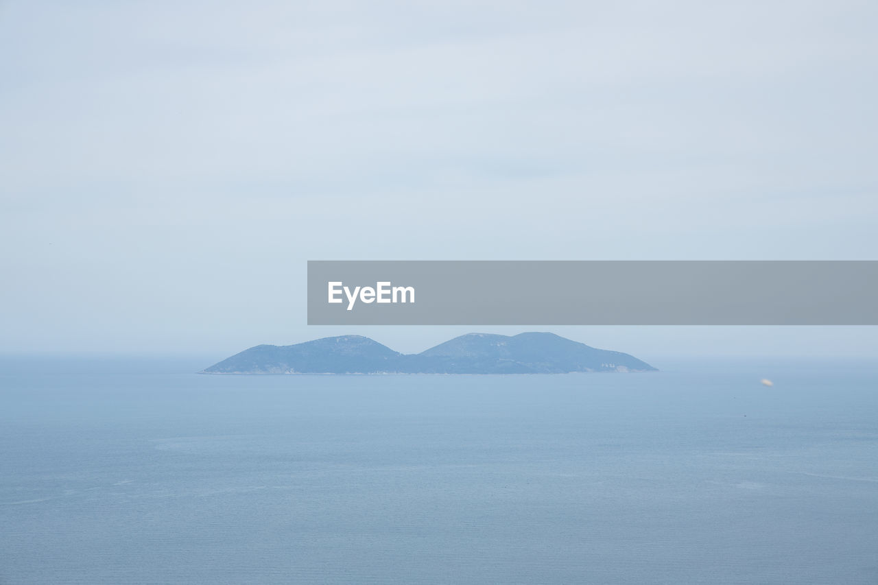 SCENIC VIEW OF SEA AND MOUNTAIN AGAINST SKY