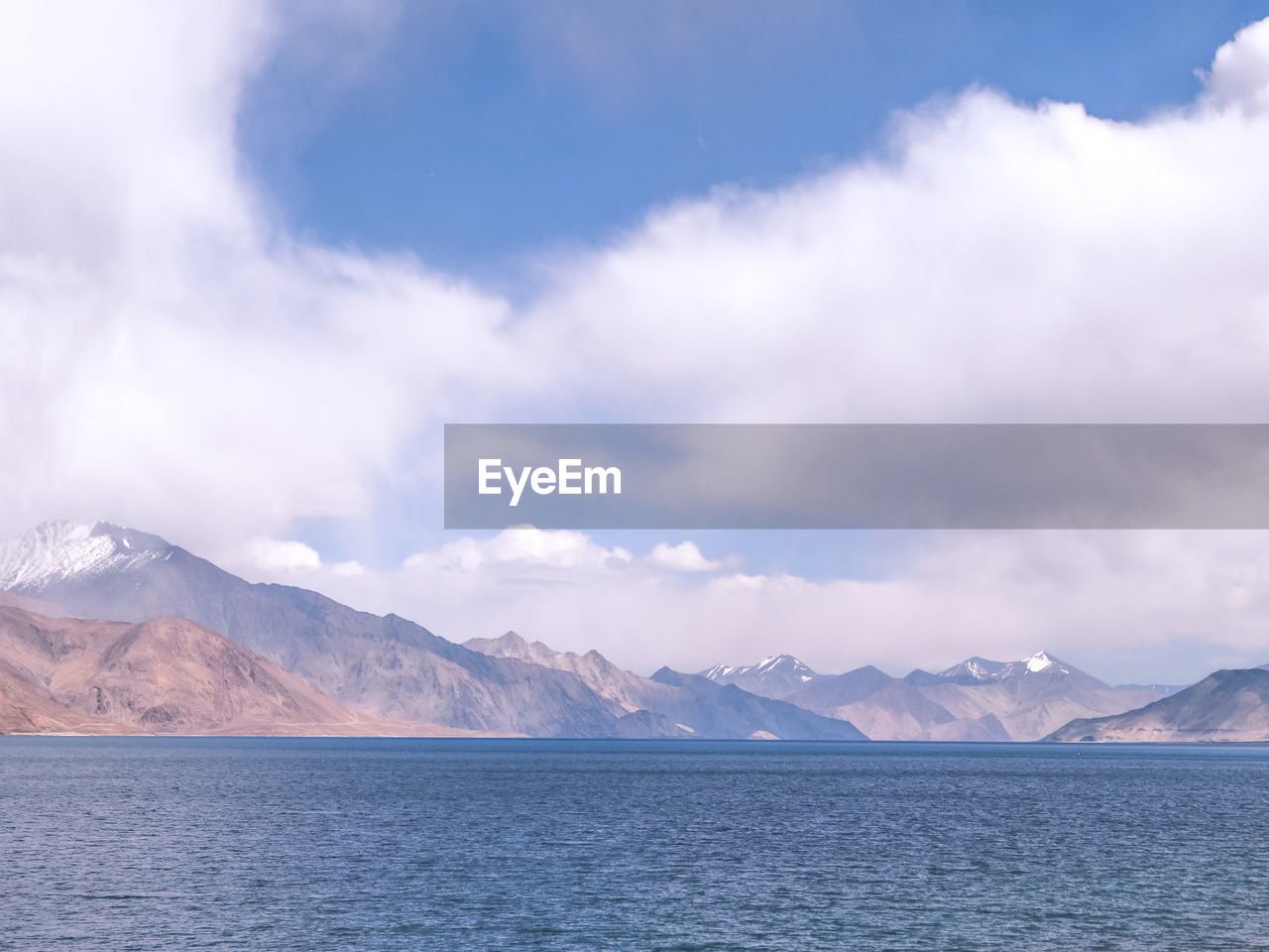 SCENIC VIEW OF SEA AGAINST MOUNTAINS